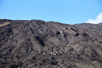 Mount Etna, Sicily, Italy. Slopes of volcano are covered with volcanic ash and frozen lava. Summer mountain landscape on sunny day
