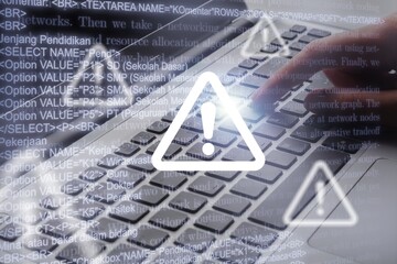 Cyber security. Man works on computer with alert sign