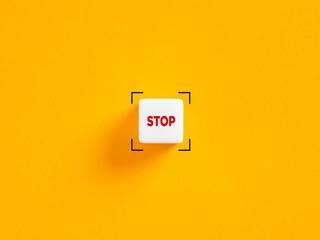 Stop push button. The word stop on white cube on yellow background. - obrazy, fototapety, plakaty
