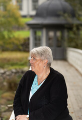 Elder woman standing on a wooden bridge