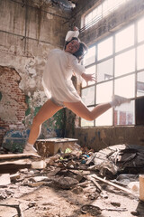 A beautiful young woman dances in an abandoned building
