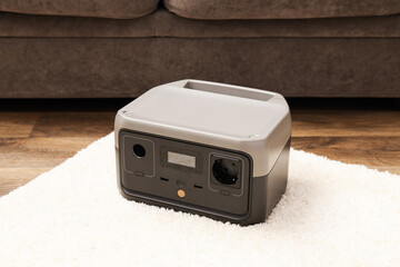 Battery station on carpet on wooden background