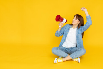 Fototapeta premium An attractive young girl with a loudspeaker in her hands