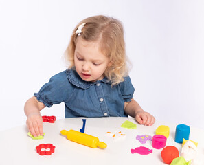 Cute little girl cuts a toy out of dough