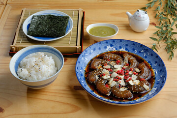 A platter of pickled shrimp in fish sauce, served with steaming rice and crispy seaweed. The shrimp are tender and flavorful, the rice is fluffy and delicious, and the seaweed adds a touch of crunch.