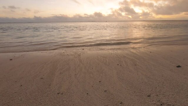 Still view lookout to Ocean Sea horizon in the Pacific during sunset orange pink sky with cloud in calm and relaxation turquoise lagoon with soft wave ponding on the beach in Aroa Rarotonga Pacific