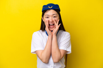Airplane Chinese woman stewardess isolated on yellow background shouting and announcing something