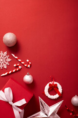 Top view of many Christmas decorations placed on the red background with an empty area. Christmas...