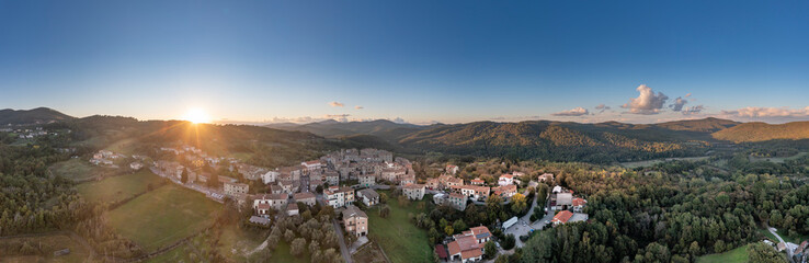 Italy, Tuscany, Torniella, Aerial panorama of mountain village at sunset