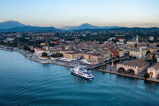 Italy, Veneto, Lazise, Aerial view of lakeshore town with ferry in foreground