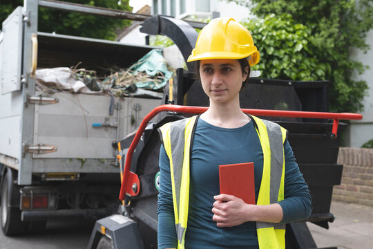 Blue collar worker holding diary near dumper truck