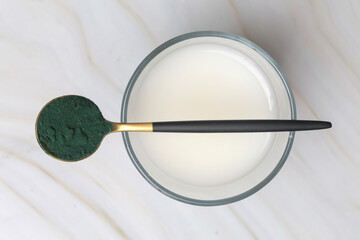 Green powder in the spoon, spirulina, alage, chlorophyll or matcha. Concept of nutritional...