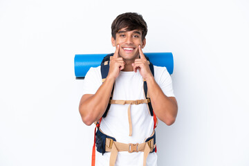 Young mountaineer woman with a big backpack over isolated white background smiling with a happy and pleasant expression