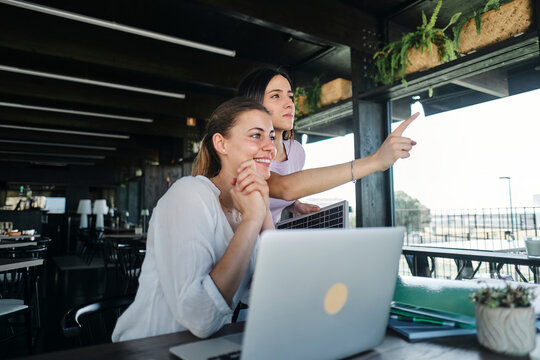 Two young women working together on sustainable resources project at coworking space