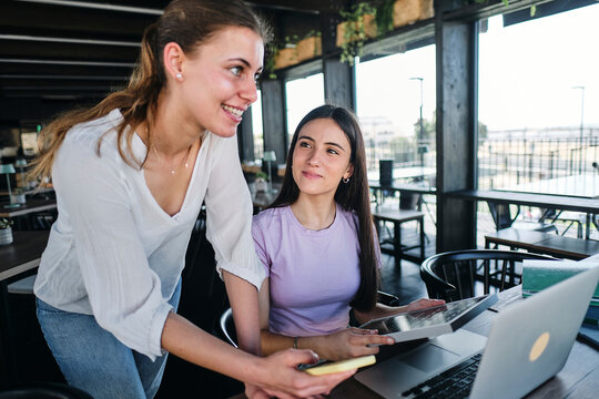 Two young women working together on sustainable resources project at coworking space