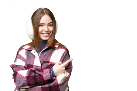 Young pretty woman wearing winter muffs over isolated chroma key background pointing finger to the side