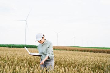 Smiling agronomist examining crops at field