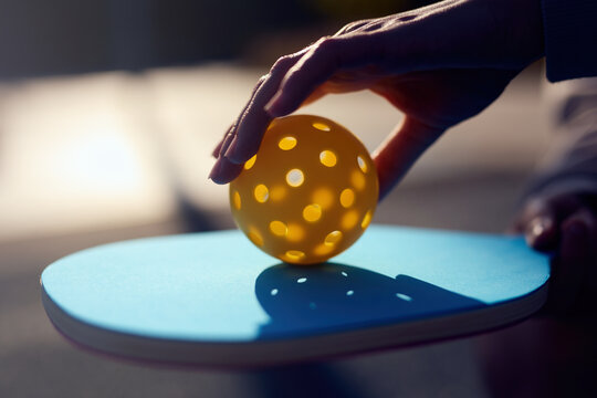 Pickler puts a ball on a pickleball racket