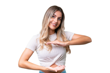 Young Uruguayan woman over isolated background holding copyspace imaginary on the palm to insert an ad