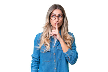 Young Uruguayan woman over isolated background showing a sign of silence gesture putting finger in...