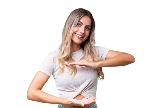 Young Uruguayan woman over isolated background holding copyspace imaginary on the palm to insert an ad