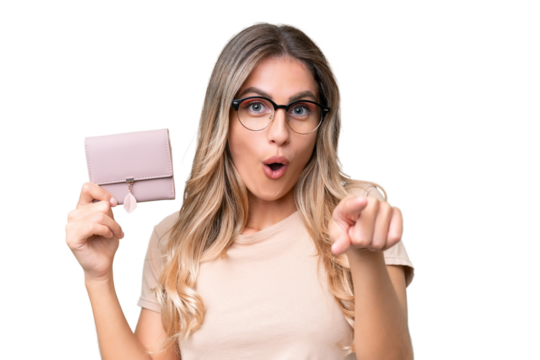 Young Uruguayan woman holding a wallet over isolated background surprised and pointing front