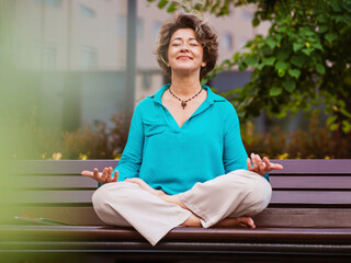 Mature businesswoman meditating on park bench
