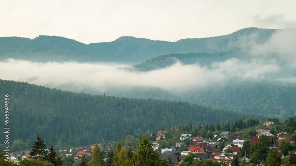 Canvas Prints Foggy morning in mountain town. Time lapse video of clouds of fog rolling between spruce and beech trees in mountains