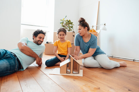 Smiling man with woman and daughter looking at model house
