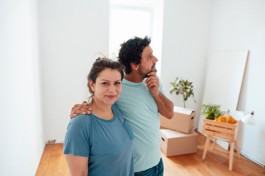 Thoughtful man standing with woman at home