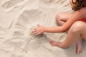 anonymous girl plays in the sand