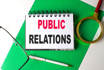 PUBLIC RELATIONS text on notebook on green paper