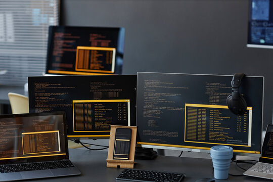 Computers and smart phone with texts on screen at desk in office