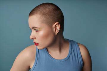 Contemplative woman with red lipstick against blue background