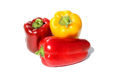 Three yellow and red peppers lie on a white background.