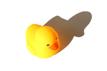 A yellow toy duck stands on a white background.	