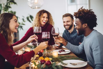 Fotobehang Group of friends toasting with red wine glasses, celebrating Christmas holidays together at a festive lunch party © Jasmina