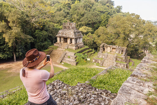 Man photographing Mayan ruins with smart phone