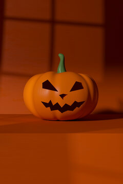 Plastic jack o lantern lying against orange background