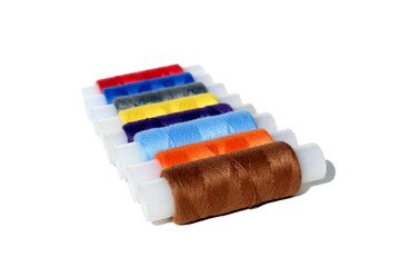 A bunch of bright multi-colored threads lie on a white background.	