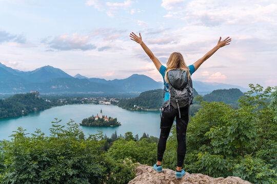Carefree hiker with arms raised standing on cliff