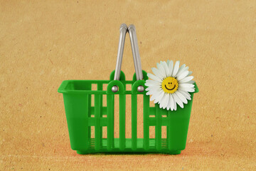 Green shopping basket with daisy flower on recycled paper background - Concept of ecology and green...