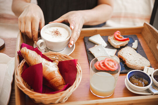 Woman having breakfast in wooden tray