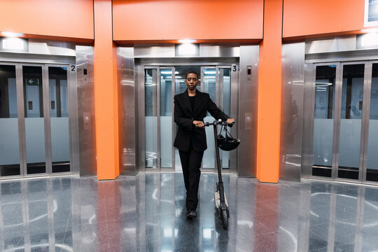 Young woman with electric push scooter at subway station