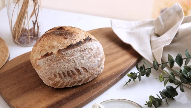 Artisan Batard Sourdough healthy Bread with leaf scoring. Open crumb high hydration Sourdough bread set on white table.