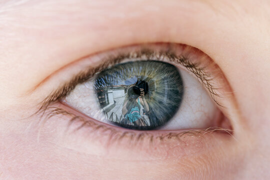Reflection of photographer in cornea of girl