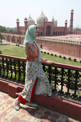 Tourist woman, beautiful girl. Badshahi Mosque, mosque in Lahore, Punjab, Pakistan. Pakistani architecture, building facade, Badshahi Mosque in mosque in Lahore, Pakistan. Landmark, monument, view
