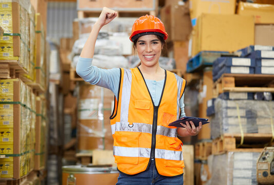factory worker raised arm up and celebrating success at work in warehouse storage