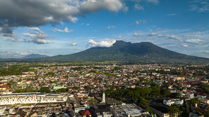 The city of Bukittinggi and Mount Marapi. A clock tower Jam Gadang. Sumatra. Indonesia.