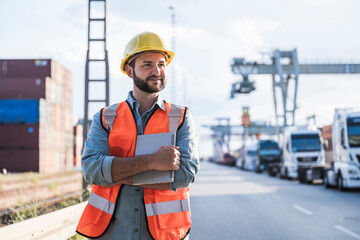 Smiling logistics worker standing in industrial district